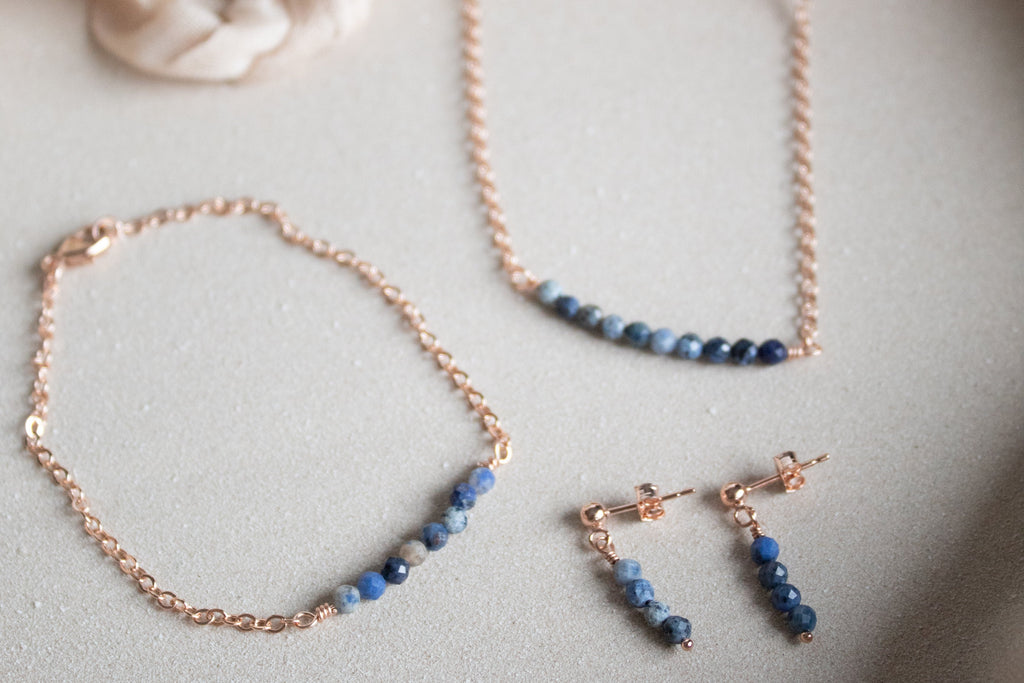 Jewelry set with necklace, bracelet, and earrings on a neutral background