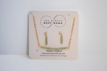 Moments and milestones peridot stud earring and necklace set in 14k gold filled on a jewelry card. 