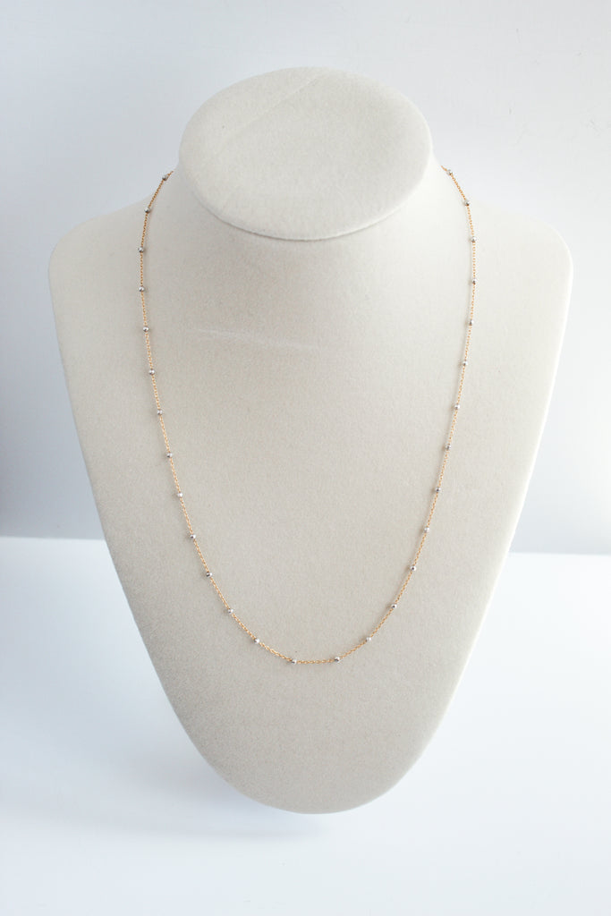 14k gold-filled chain necklace accented with sterling silver satellite beads, elegantly displayed on a jewelry stand.