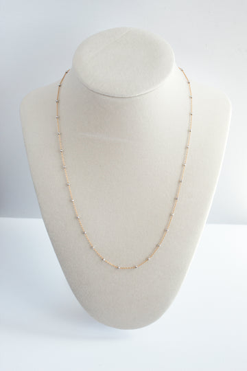 14k gold-filled chain necklace accented with sterling silver satellite beads, elegantly displayed on a jewelry stand.