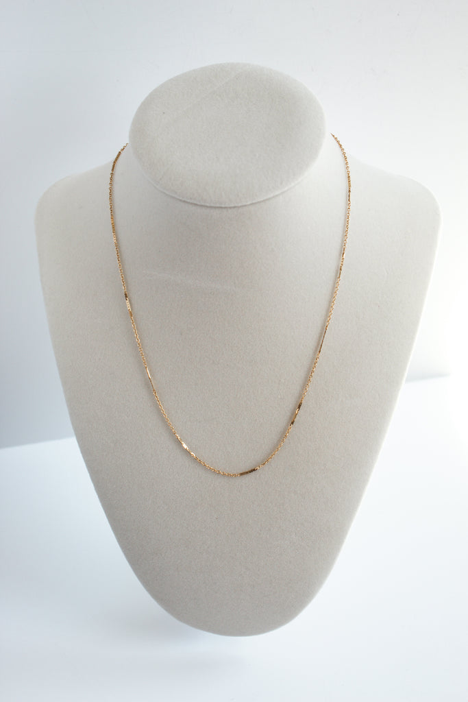 14k gold filled dapped bar necklace, featuring a textured bar pendant, elegantly presented on a necklace display stand.