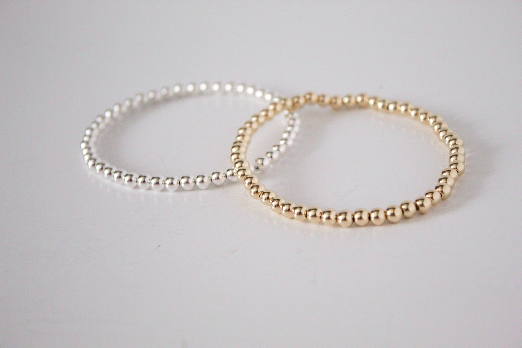 3mm 14k gold-filled and sterling silver metal stretch bracelet, featuring dainty gold and sterling silver beads for a minimalist look, displayed on a white background. 