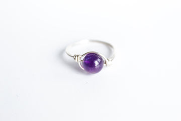 Sterling Silver wire-wrapped ring featuring a round amethyst gemstone.