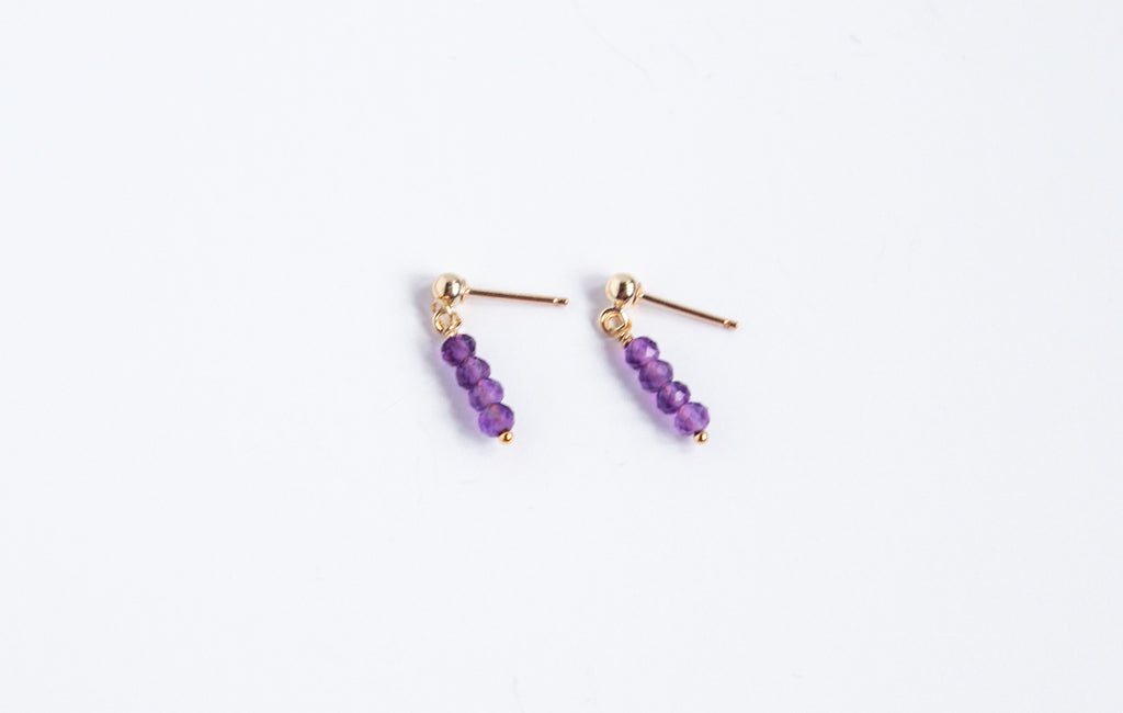 14k gold filled stud earrings with amethyst gemstones from the Moment and Milestone Collection, displayed on a white background.