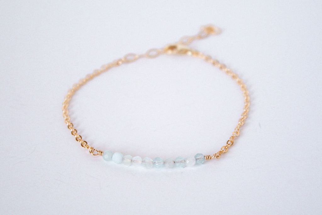 14k gold filled chain bracelet from the Moments and Milestone collection featuring faceted round aquamarine gemstones.