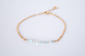 14k gold filled chain bracelet from the Moments and Milestone collection featuring faceted round aquamarine gemstones.