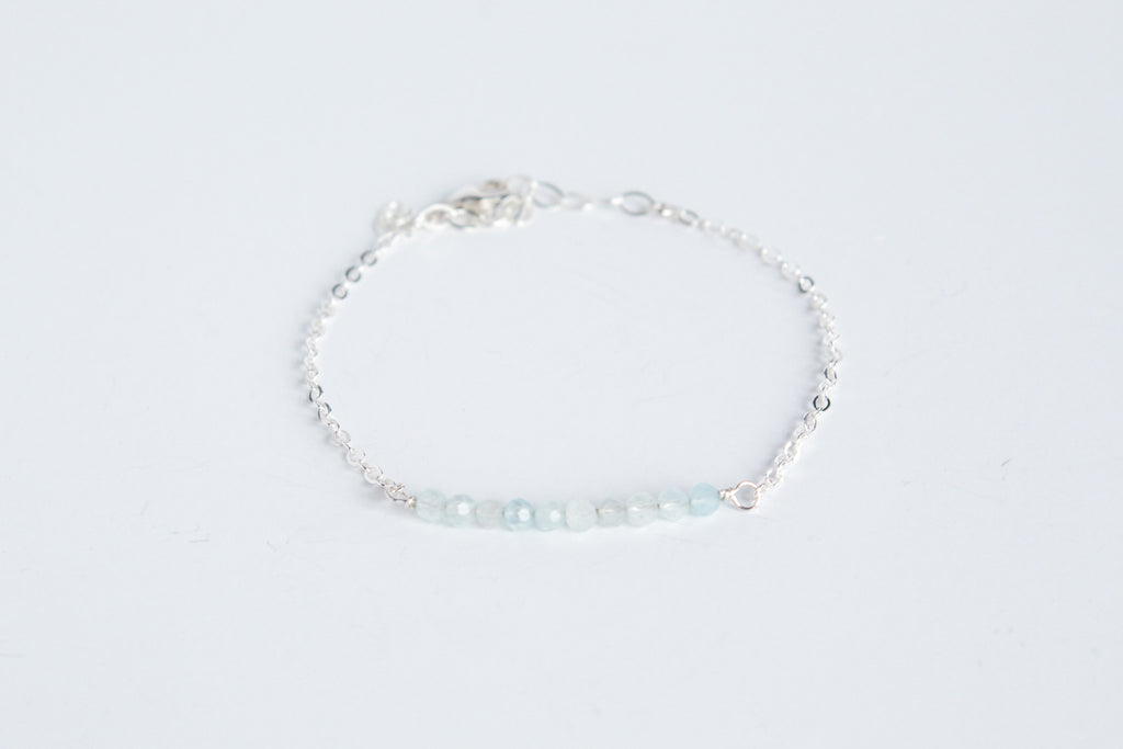 Sterling silver chain bracelet from the Moments and Milestone collection featuring faceted round aquamarine gemstones.