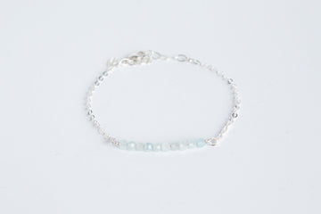 Sterling silver chain bracelet from the Moments and Milestone collection featuring faceted round aquamarine gemstones.