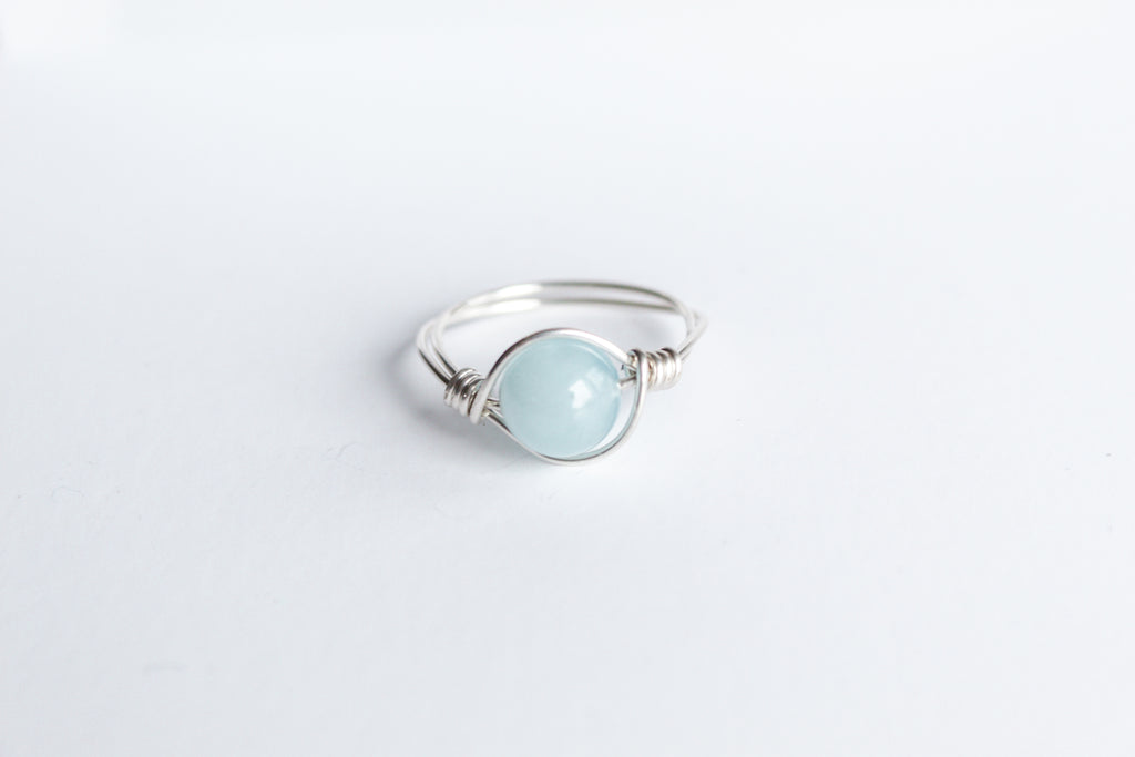 Sterling Silver wire-wrapped ring featuring a round aquamarine gemstone.