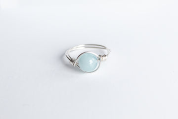 Sterling Silver wire-wrapped ring featuring a round aquamarine gemstone.