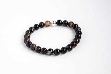 Black tourmaline gemstone stretch bracelet with earthy tones, showcased on a white background.