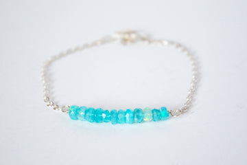 Sterling silver chain bracelet from the Moments and Milestone collection featuring faceted round blue Opal gemstones.