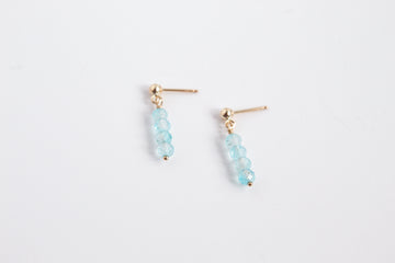 14k gold filled stud earrings with blue topaz gemstones from the Moment and Milestone Collection, displayed on a white background.