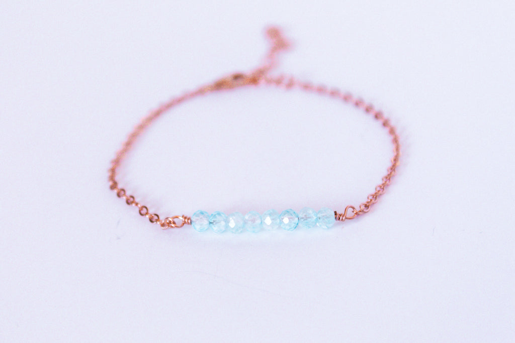 Moments and Milestone chain bracelet with blue topaz faceted round gemstone on a 14k rose gold filled chain.