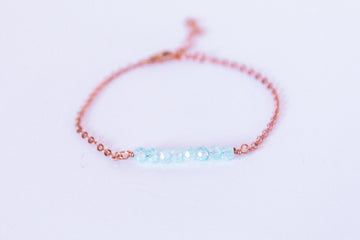 Moments and Milestone chain bracelet with blue topaz faceted round gemstone on a 14k rose gold filled chain.