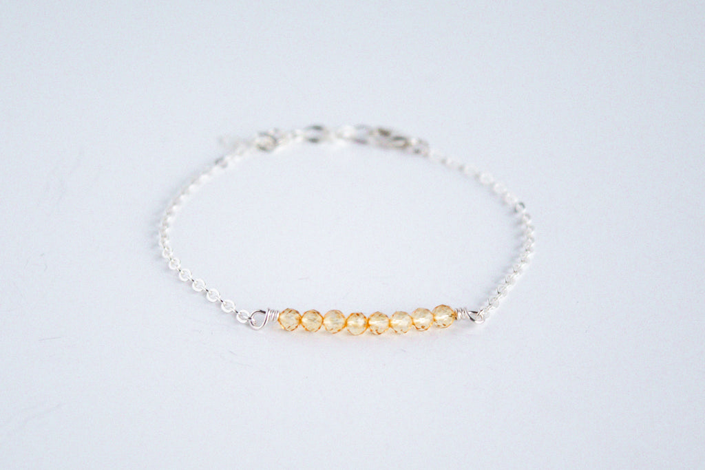 Sterling silver chain bracelet from the Moments and Milestone collection featuring faceted round citrine gemstones.