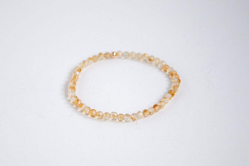 Handcrafted stretch bracelet with citrine gemstones, photographed on a white background.