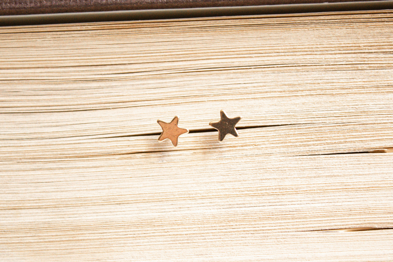 14k gold filled star studs within the pages of a book. 
