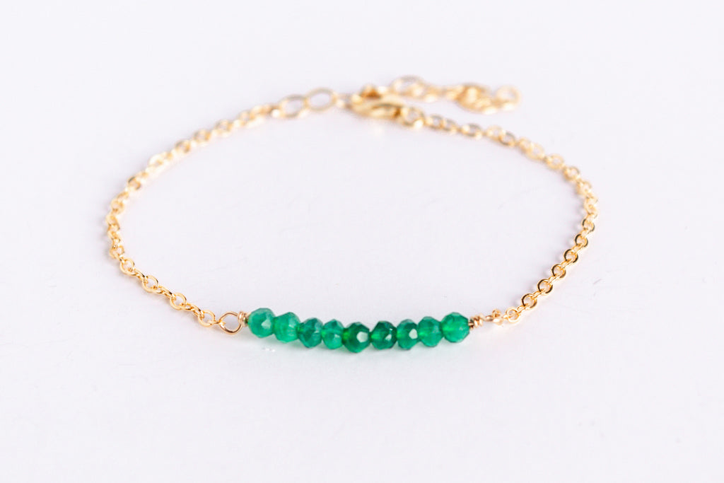 14k gold filled chain bracelet from the Moments and Milestone collection featuring faceted round emerald gemstones.