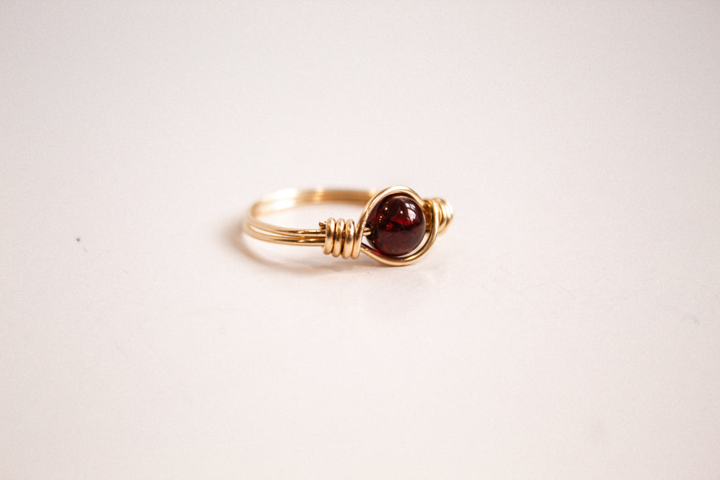 Side view of a handcrafted wire-wrapped ring featuring Garnet gemstone.