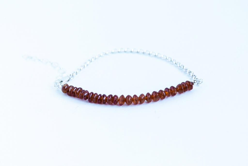 Handcrafted garnet gemstone with sterling silver rolo chain from the Perfect Balance Collection, displayed on a white background.