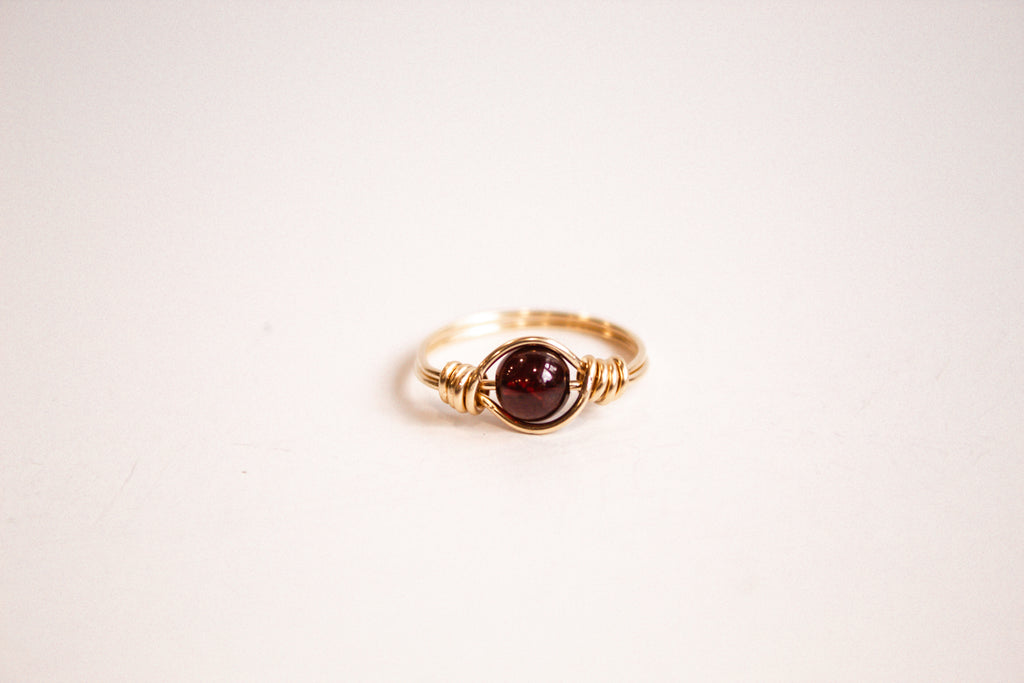 14k gold filled wire-wrapped ring featuring a garnet gemstone.