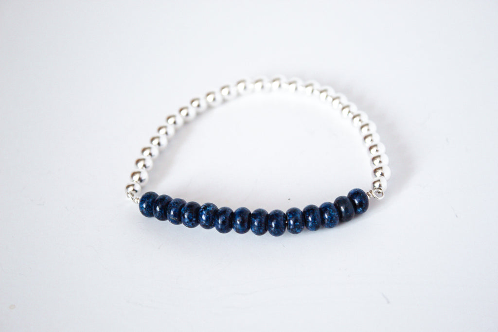 Handcrafted lapis lazuli gemstone and sterling silver stretch bracelet from the Perfect Balance Collection, displayed on a white background.