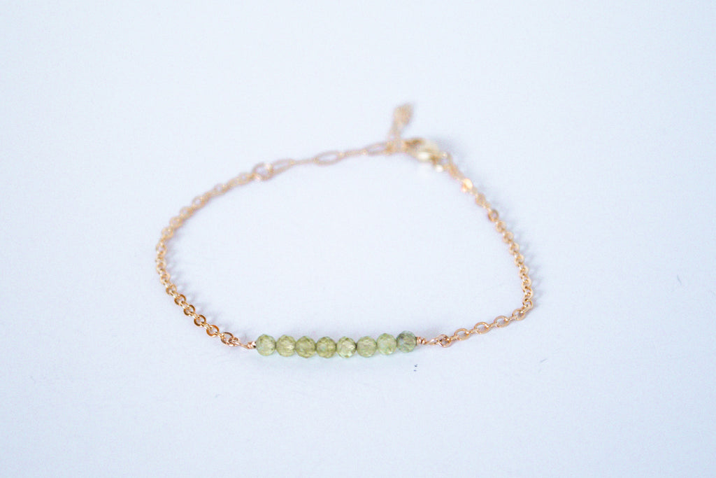 14k gold filled chain bracelet from the Moments and Milestone collection featuring faceted round peridot gemstones.