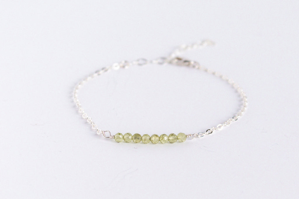 Sterling silver chain bracelet from the Moments and Milestone collection featuring faceted round peridot gemstones.