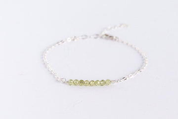 Sterling silver chain bracelet from the Moments and Milestone collection featuring faceted round peridot gemstones.