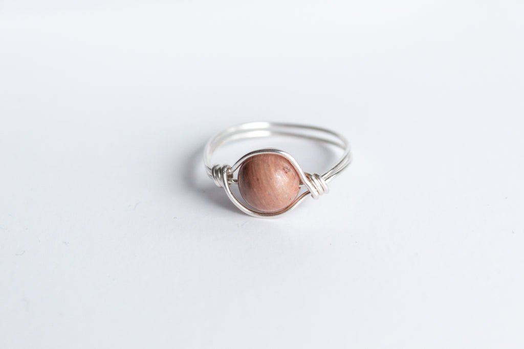 Sterling Silver wire-wrapped ring featuring a round pink rhodonite gemstone.