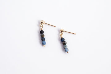 Moment and Milestone stud earrings in 14k gold filled and dangling sapphire gemstones, symbolizing life’s meaningful moments, displayed on a white background.