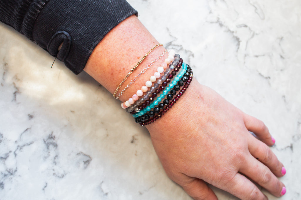 Mixed gemstone stretch bracelets in a stack on a model from the mama's stretch bracelet collection. 