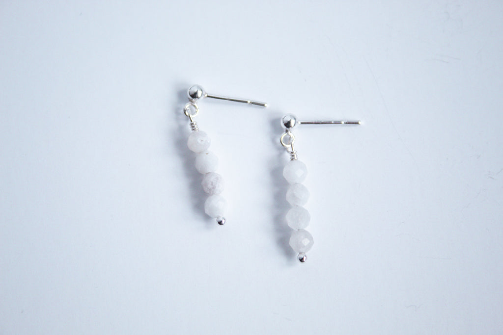 Moment and Milestone stud earrings in sterling silver and dangling moonstone gemstones, symbolizing life’s meaningful moments, displayed on a white background.