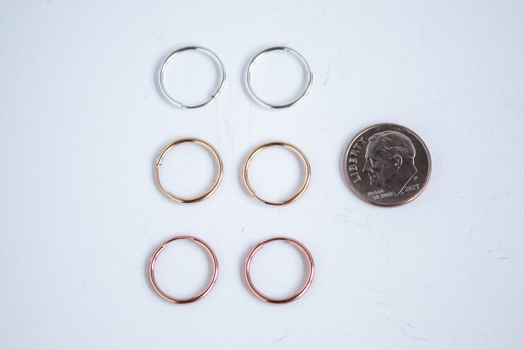 Always On Hoops in sterling silver, 14k gold filled and 14k rose gold filled displayed on a white background next to a dime for size comparison. 