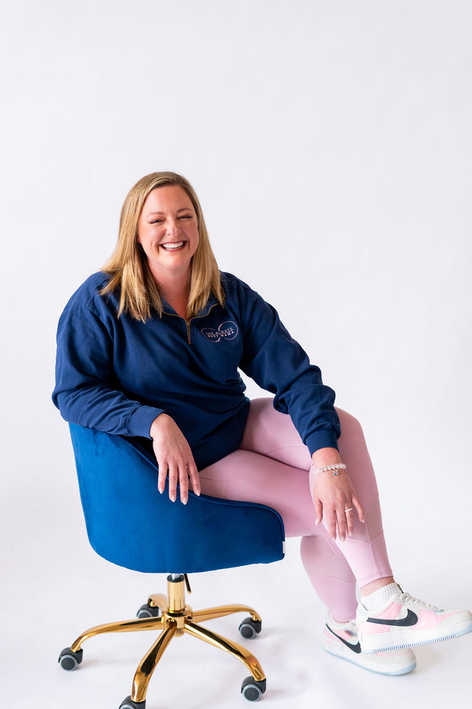 Jewelry designer Becky sitting in a chair during a brand photo shoot. 