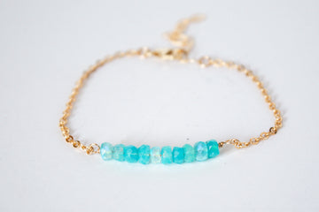 14k gold filled chain bracelet from the Moments and Milestone collection featuring faceted round blue Opal gemstones.