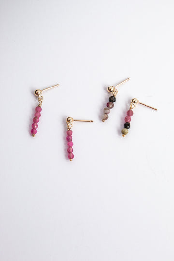 Moment and Milestone stud earrings in 14k gold filled and dangling pink and mixed tourmaline gemstones, symbolizing life’s meaningful moments, displayed on a white background.