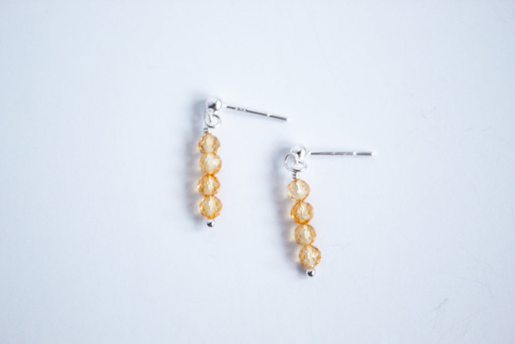 Moment and Milestone stud earrings in sterling silver and dangling citrine gemstones, symbolizing life’s meaningful moments, displayed on a white background.