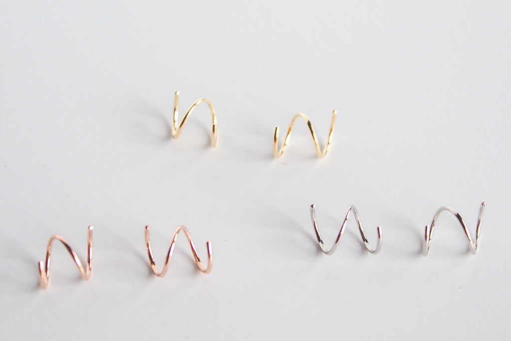 Dainty twisted hoop earrings in 14k gold filled, sterling silver, and 14k rose gold filled material, shown on a white background. 